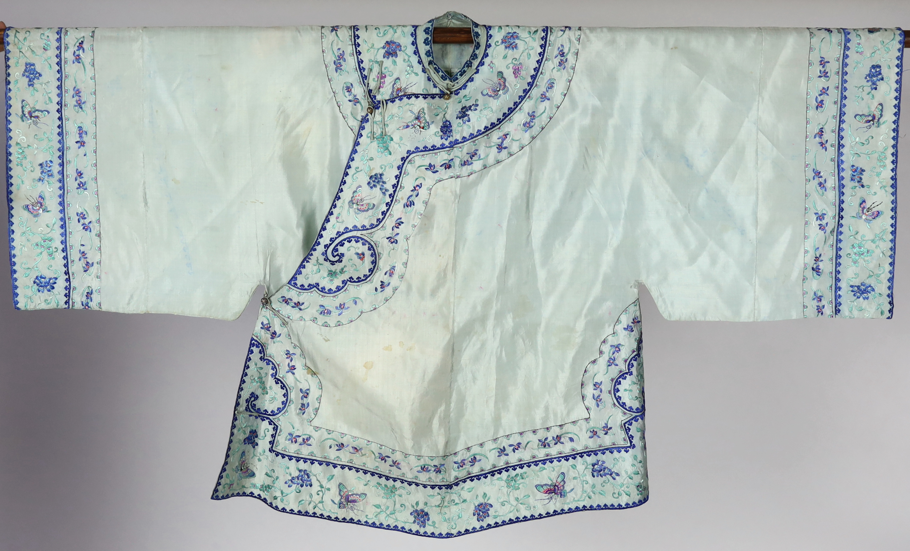 A 1930's Chinese silk embroidered robe, in pale turquoise silk with wide pastel embroidery of butterflies and flowers, 88cm long